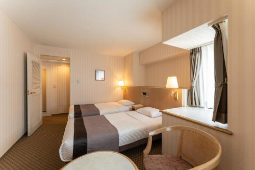 金泽HOTEL MYSTAYS Kanazawa Katamachi的酒店客房设有两张床和窗户。