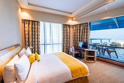 麦纳麦精英温泉度假村酒店的酒店客房设有一张大床和一个阳台。