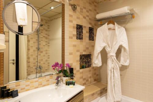 麦纳麦精英温泉度假村酒店的浴室墙上挂着白色的长袍