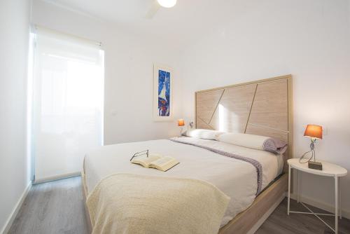 卡尔佩Apartamento Natsu - PlusHolidays的白色的卧室设有一张大床和一个窗户