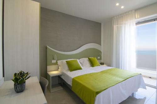 里乔内Residence Flow-R的一间卧室配有一张大床和绿色床头板