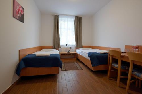 索波特米拉华酒店的小房间设有两张床和一张桌子