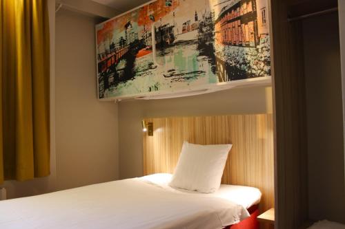 韦斯特罗斯韦斯特罗斯早安酒店的卧室配有一张床,墙上挂有绘画作品