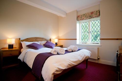 泰晤士河畔里士满纽约玫瑰宾馆的一间卧室配有一张大床和毛巾