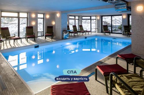 布克维Ribas Karpaty的酒店设有一个配有桌椅的大型游泳池
