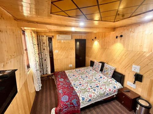 古尔马尔格Gulmarg View Cottage的木制客房内的一间卧室,配有一张床