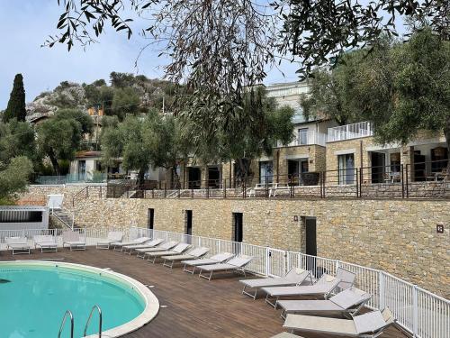 文蒂米利亚Ibiza style bungalows with sea views in Balzi Rossi的一座带躺椅的游泳池和一座建筑