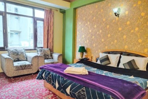 斯利那加Hotel Mehar Srinagar的卧室配有床、椅子和窗户。