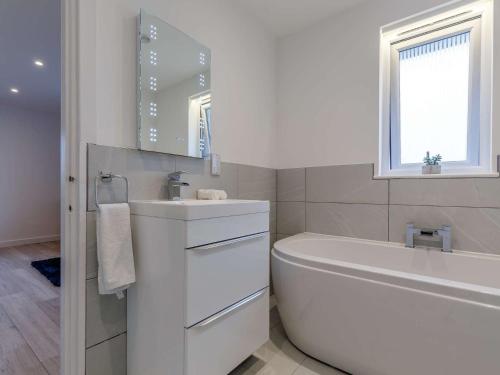 圣贾斯特1 Bed in Sennen 85330的白色的浴室设有浴缸和水槽。