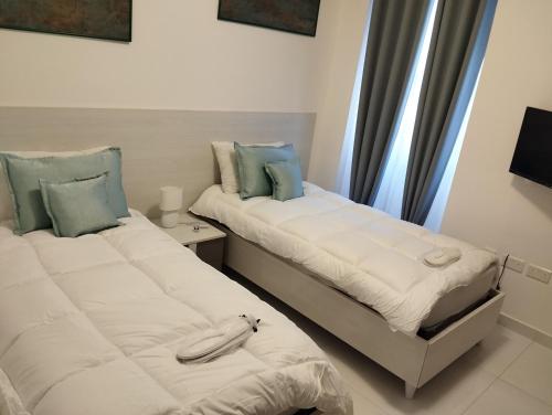 斯利马Pearl Apartments的两张睡床彼此相邻,位于一个房间里