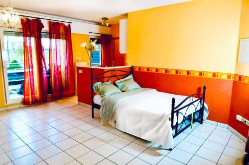 蒙多夫莱班Studio - Thermes de Mondorf的一间卧室设有一张橙色和黄色墙壁的床。