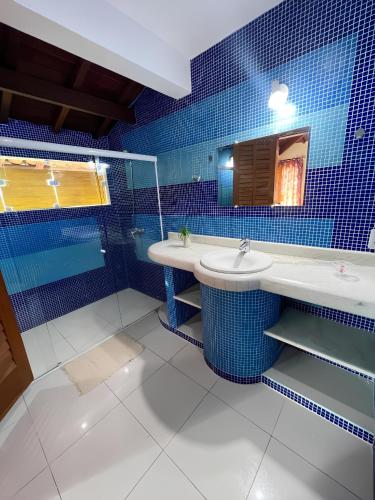 塞古罗港Pousada Casa Mucugê的蓝色瓷砖浴室设有两个水槽和镜子