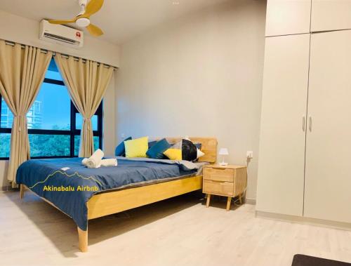 哥打京那巴鲁JQ Citypads by Golden Stay的一间卧室设有一张床和一个大窗户