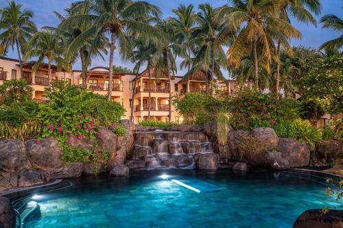 弗利康弗拉克毛里求斯希尔顿Spa度假酒店的棕榈树度假村前的游泳池