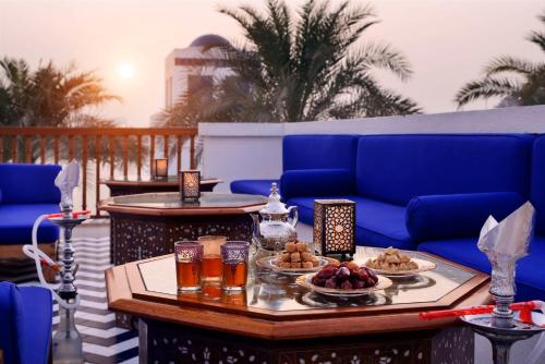 迪拜迪拜柏悦酒店的露台上的桌子上摆放着食物和饮料