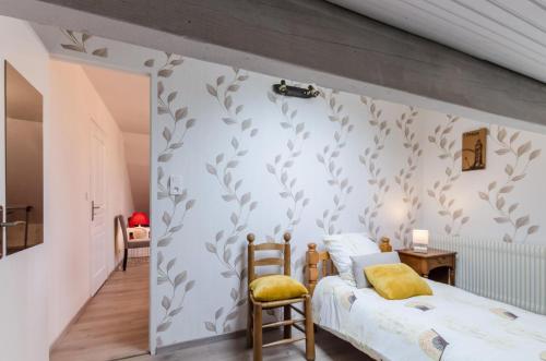 LandrevilleLa rose d'henri的卧室拥有白色墙壁,上面有灰色的叶子