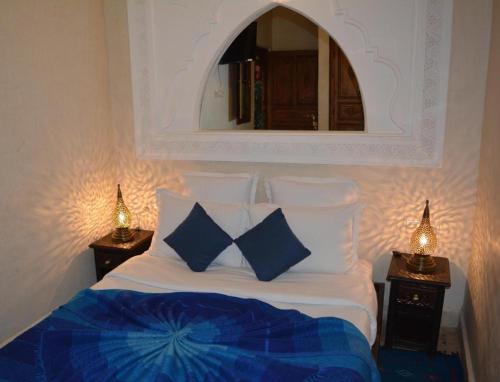 马拉喀什Riad Ghali Hotel & SPA的一张带蓝色和白色枕头及镜子的床