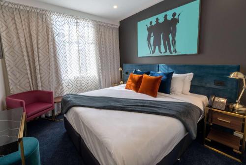 惠灵顿TRYP by Wyndham Wellington, Tory Street的酒店客房配有一张带橙色枕头的大床