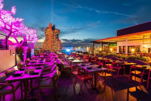 好莱坞Dolce by Wyndham Hollywood的晚上在屋顶上设有桌椅的餐厅