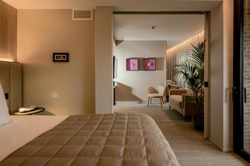亨克Stiemerheide - The Urban Hotel & Golf Retreat的酒店客房设有床和客厅。