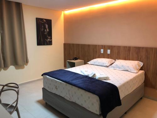 德尔米鲁戈韦亚Premium Hotel的一间卧室配有一张带蓝色毯子的大床