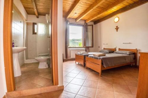 LàconiOASI FRANCESCANA SANT'IGNAZIO DA LACONI的一间卧室设有一张床和一间浴室。