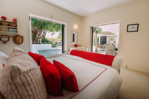 普利登堡湾Rothersands 16的卧室配有带红色枕头的白色床