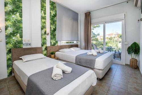 利迈纳里亚Hotel Discovery Thassos的带大窗户的客房内的两张床