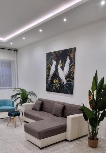 罗马Appartamento Caracas的客厅配有沙发和墙上的绘画