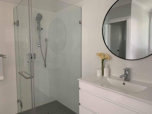 杰斯蒙Maya Newcasle 6 bedrooms home的白色的浴室设有水槽和镜子