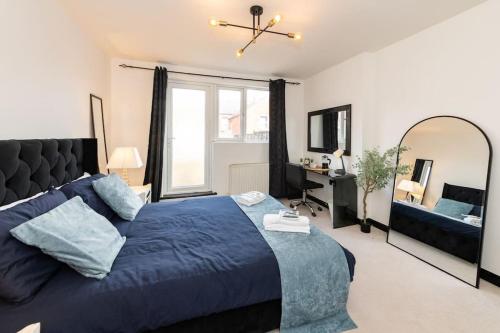 雷丁Well Equipped Apartment for Relocators and Contractors的一间卧室配有蓝色的床和大镜子