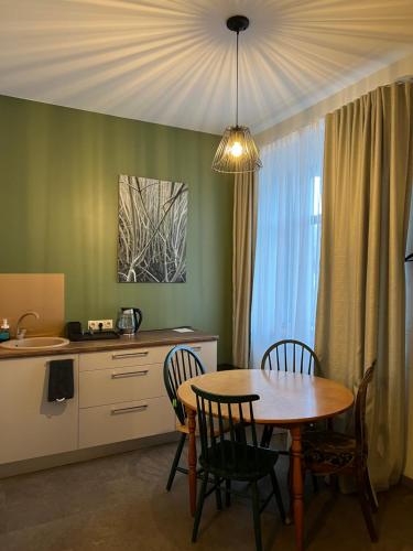 利加特内Zeit Apartment的厨房以及带桌椅的用餐室。
