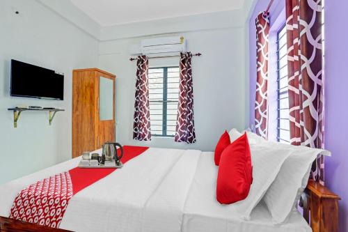 KazhakuttamOYO Bevis的卧室配有带红色枕头的大型白色床