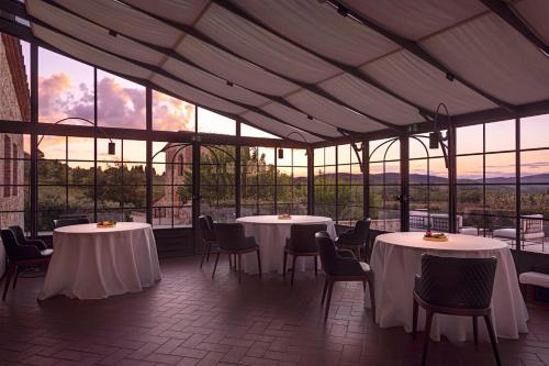 卡斯德尔诺沃贝拉登卡The Club House的餐厅设有白色的桌椅和窗户。
