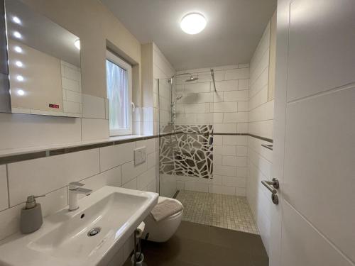 措森Ferienhaus Eichhörnchen的白色的浴室设有水槽和卫生间。