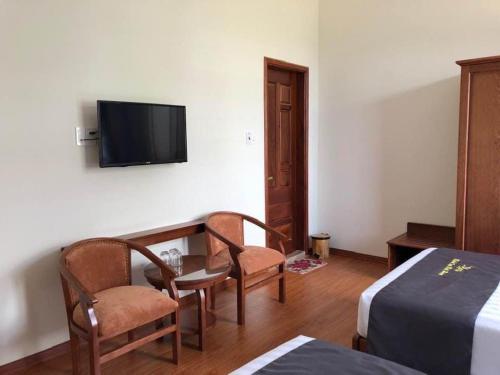 Plei Brel (2)Khách sạn Khải Hoàn的酒店客房配有桌椅和电视。