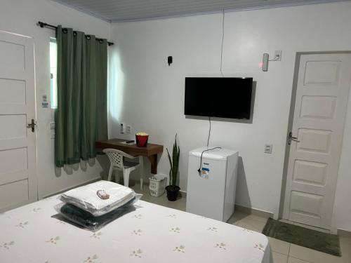 里约布兰科Pousada Amazônia的卧室配有一张床,墙上配有电视