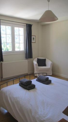 SaillansLa Maison Rose的一间卧室配有一张床,上面有两条毛巾