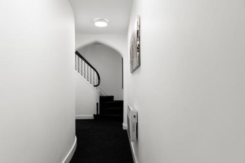 布赖尔利希尔Vault Chambers的一条带白色墙壁和楼梯的走廊