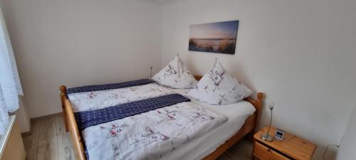 萨斯尼茨Ferienwohnung Kollwitz的小卧室配有带白色床单和枕头的床
