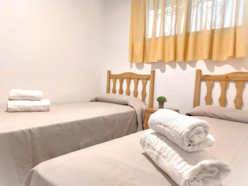 坎布里尔斯Rentalmar Sol de España - Mas d'en Gran的客房内的两张床和毛巾