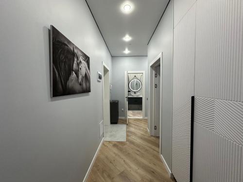 塔尔迪科尔Новый ремонт 2-х комн. в центре города的走廊设有白色墙壁、木地板和镜子