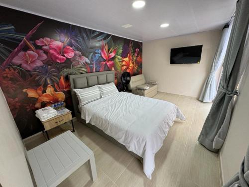 ChachagüíSIETE COLORES的一间卧室设有一张床和花墙