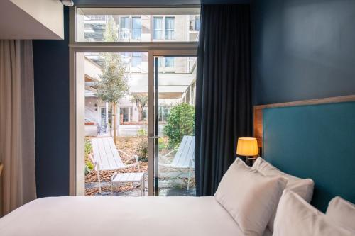 南特Hôtel de la Cité的一间卧室设有一张床和一个大窗户