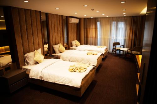 伊斯坦布尔Sabiha Sultan Hotel-Karakoy的酒店客房设有三张床和一张桌子