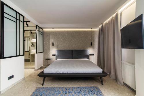 雅典Kolonaki Square Central Penthouse的一间卧室配有一张床和一台电视
