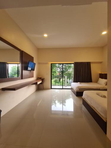 DompuMerpati inn hotel的一间卧室设有两张床和大窗户