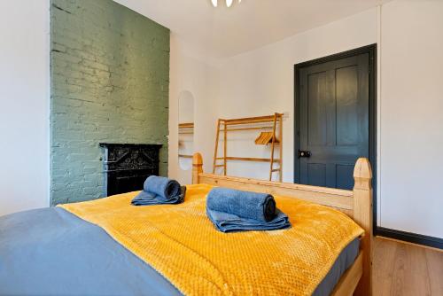 尤托克西特Sally’s Cottage - Uttoxeter: Close to Alton Towers的一间卧室配有一张带2条蓝色毛巾的床