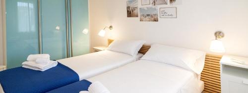 布多尼Turquoise & Wood Stylish House 23的卧室配有两张白色的床。