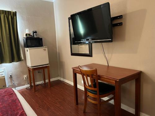 北山北山家乡旅馆的一间设有一张桌子和一台墙上的电视的房间